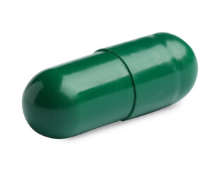 One green pill on white background. Medicinal treatment