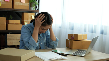 Desperate Asian woman stress headache depressed from startup small business at home office. Failure...