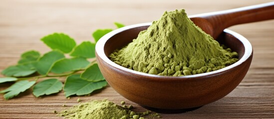 Moringa powder that has been dried placed on a background made of wood