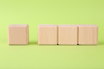 International Organization for Standardization. Wooden cubes with check mark and abbreviation ISO on light green background