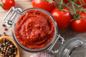 Jar of tasty tomato paste and ingredients on table, flat lay