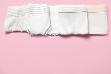 Stylish folded women's underwear on pink background, flat lay. Space for text