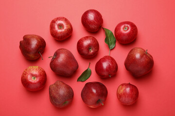 Ripe red apples and green leaves on color background, flat lay