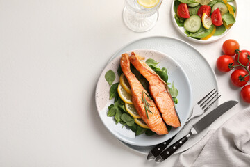 Healthy meal. Pieces of grilled salmon, spinach, lemon and rosemary served on white table, flat lay. Space for text