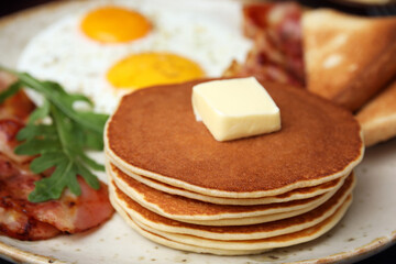 Tasty pancakes with butter on plate, closeup