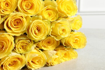 Beautiful bouquet of yellow roses on light grey table, closeup