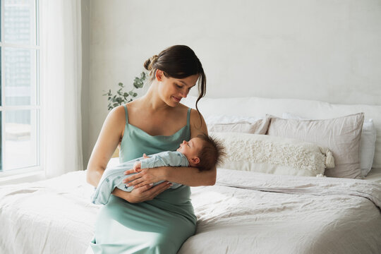 Loving mom carying of her newborn baby at home.