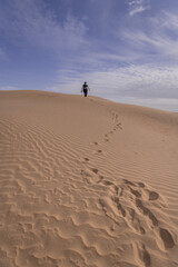 Fototapeta na wymiar Sunset at Gobi desert, huge dunes with standing woman, Mongolia.
