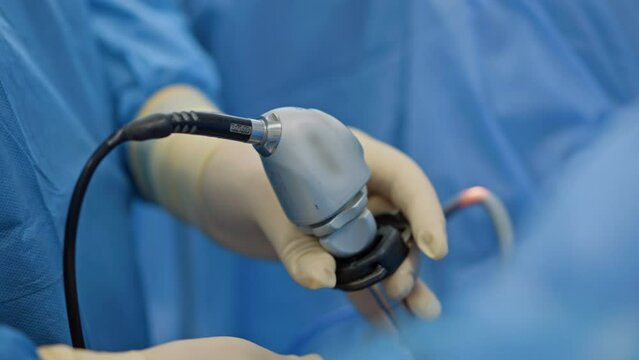 Surgical device in the gloved hand of a doctor. Close up. Tool for minimally invasive operation.