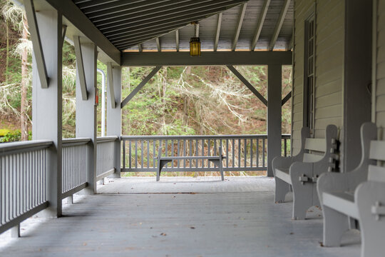 Afternoon fall, autumn photo of a porch with a single bench overlooking a natural vista, view upstate New York.	