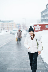 Woman tourist sightseeing in Niseko city with Snow in winter season. landmark and popular for...