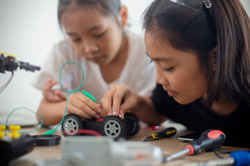 nventive kids learn at home by coding robot cars and electronic board cables in STEM. constructing robot cars at home