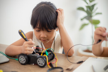 nventive kids learn at home by coding robot cars and electronic board cables in STEM. constructing robot cars at home