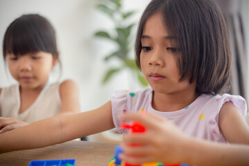 Adorable little girl playing toy blocks in a bright room