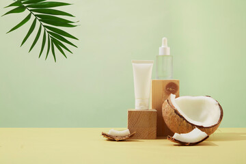 Fototapeta na wymiar Pastel background with unlabeled cosmetic bottles placed on wooden podium. Fresh coconut and tropical palm leaves. Mockup for vegan cosmetics advertisement.
