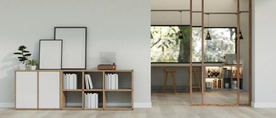 A modern, minimal room with blank frames mockup and a vinyl record player on a bookcase.