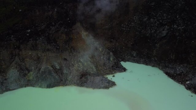 Top View Of The Famous Kawah Putih White Crater with steam rising from a vent In Bandung, West Java, Indonesia - aerial drone shot