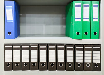 blue, green and blac binder folder wit different size on rack