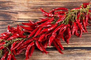 A bunch of ripe red hot chili peppers on wooden table.