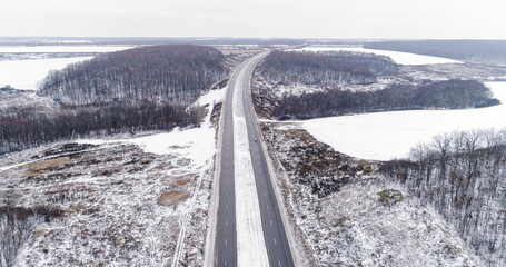 Aerial winter track. Snowy road. White frozen forest lakes cloudy day countryside asphalted...