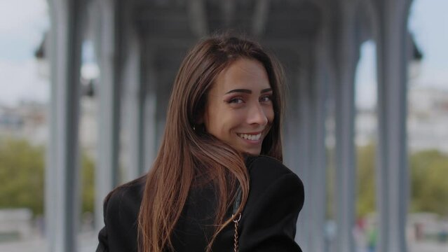 Attractive brunette model looks back to camera and smiles