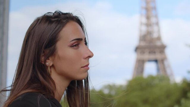 Beautiful Parisian brunette with Eiffel tower in background