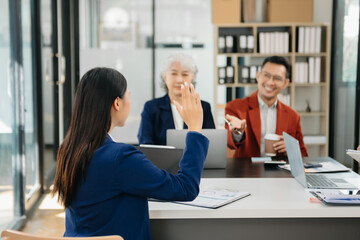 Group of young Asian business people discussing business plan at startup in office