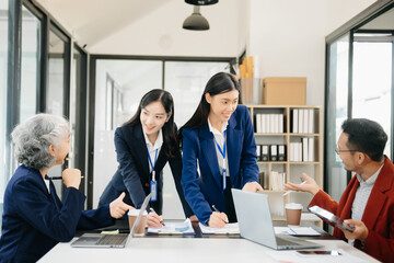 Group of young Asian business people discussing business plan at startup in office
