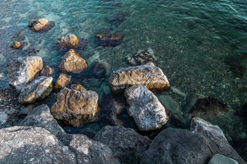A beach with a breakwater made of large stone boulders. A breakwater made of stones. View of the...