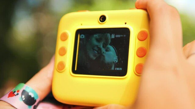 Young Happy Couple Captures Kissing Selfies with a Vibrant Yellow Plastic Photo Camera, Bright Moments 4K Lifestyle Travel Footage.