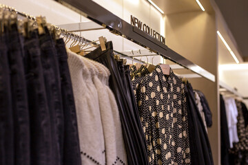 Women's autumn black and white clothes hanging on rail and the inscription on top - New collection