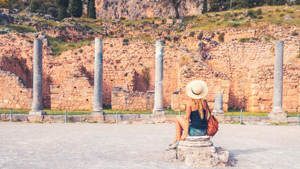 Woman tourist visiting famous touristic site of Delphi in Greece