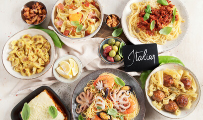 Assortment of Italian pasta dishes on light bachground. Traditional food concept.