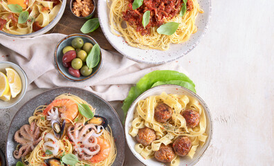 Assortment of Italian pasta dishes on light bachground. Traditional food concept.