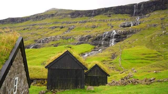 Establishing pan shot of Saksun village with grass turf houses roofs, Faroe