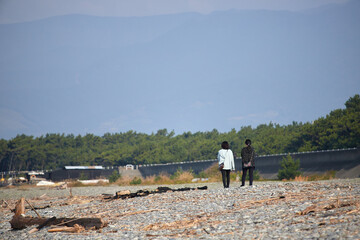 朝の海岸で散歩している二人の女性の姿