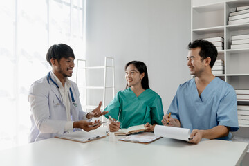 A group of male and female doctors sat and talked about the patient's history, There was a meeting about major surgery, The doctor takes the patient's documents and discusses them with team.
