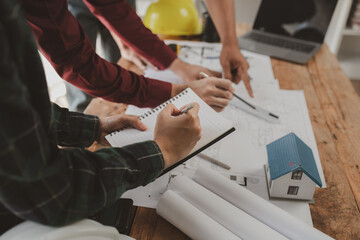 Architects and engineers work together to come up with solutions to house building problems, The property is about to be designed by a group of engineers, Architects are reviewing plans together.