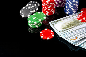 Poker chips and dollar bills on black background studio shot