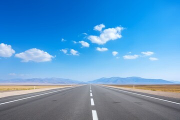 Fototapeta premium An open road stretching to the horizon under a blue sky