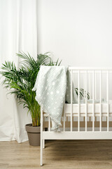 Muslin baby blanket hanging on child's bed in nursing room - obrazy, fototapety, plakaty