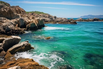 Fototapeta na wymiar Coastal rocks meeting the turquoise waters of the ocean