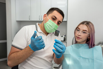 dentist explains the details of an x-ray to his female patient.