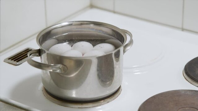 Multiple eggs getting boiled in a saucepan. Time-lapse