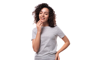 Fototapeta na wymiar authentic cute slim curly woman with black hair dressed in casual gray t-shirt on white background with copy space