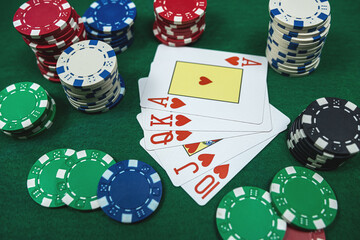 The winning combination  Royal flush with chips at casino table