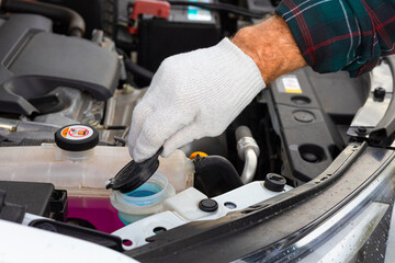 the driver pours fluid into the washer reservoir.