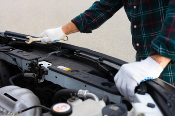 the driver inspects the engine compartment of the car.