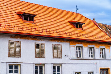 A white building with a red roof and windows. A Stunning White Building with a Vibrant Red Roof and Elegant Windows