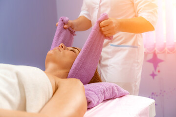 Obraz na płótnie Canvas Relaxing massage. European woman getting head massage in spa salon, side view